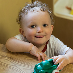 Toddler smiling while playing with toy