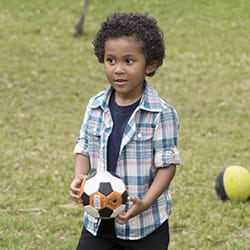 Boy playing outside holding soccer ball