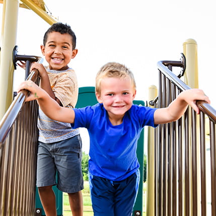 two boys on play structure outside of daycare