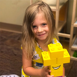 Girl playing with yellow legos